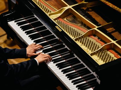 Hands of classical pianist playing his piano during a concert.